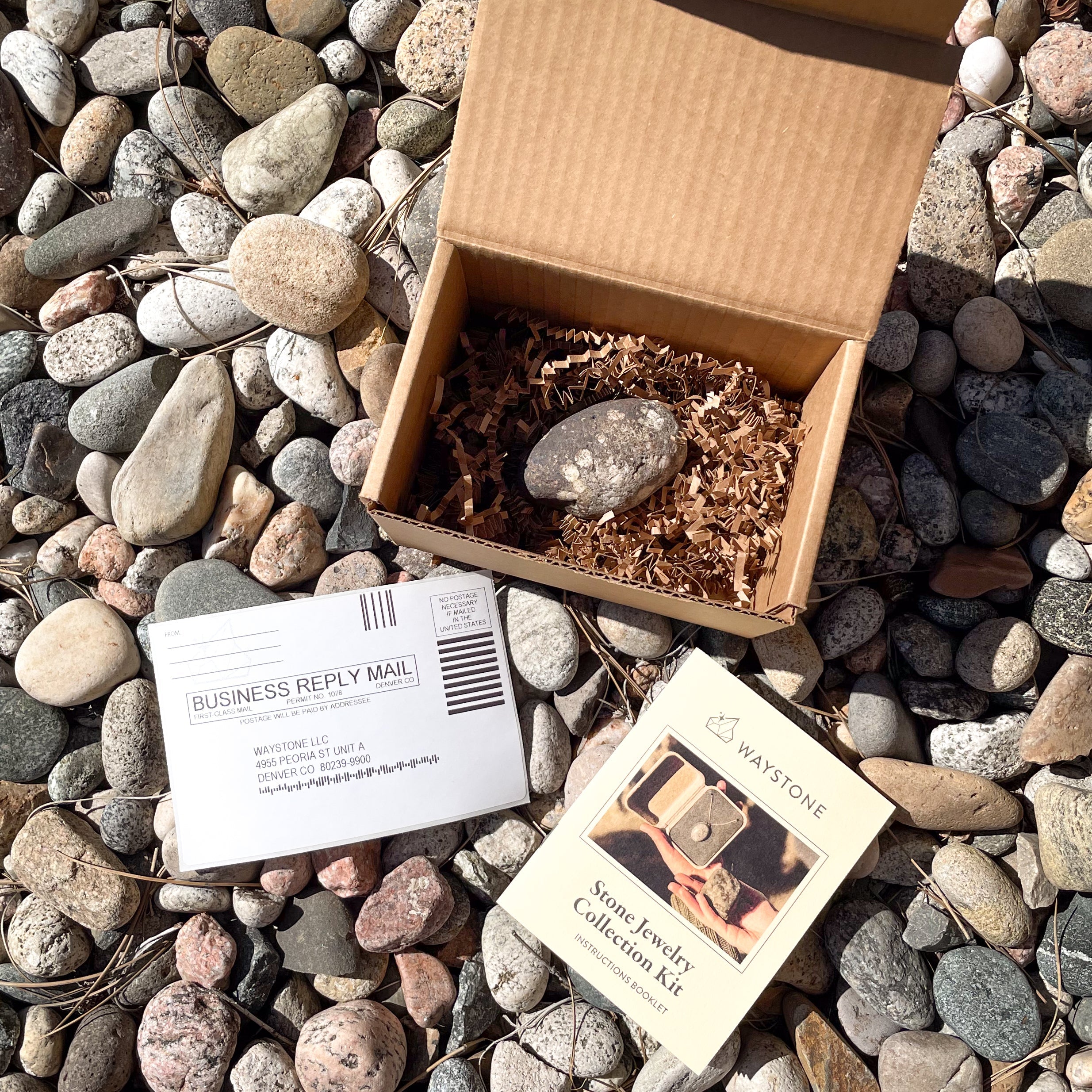 A stone in an open kraft box ready to send to make into custom jewelry