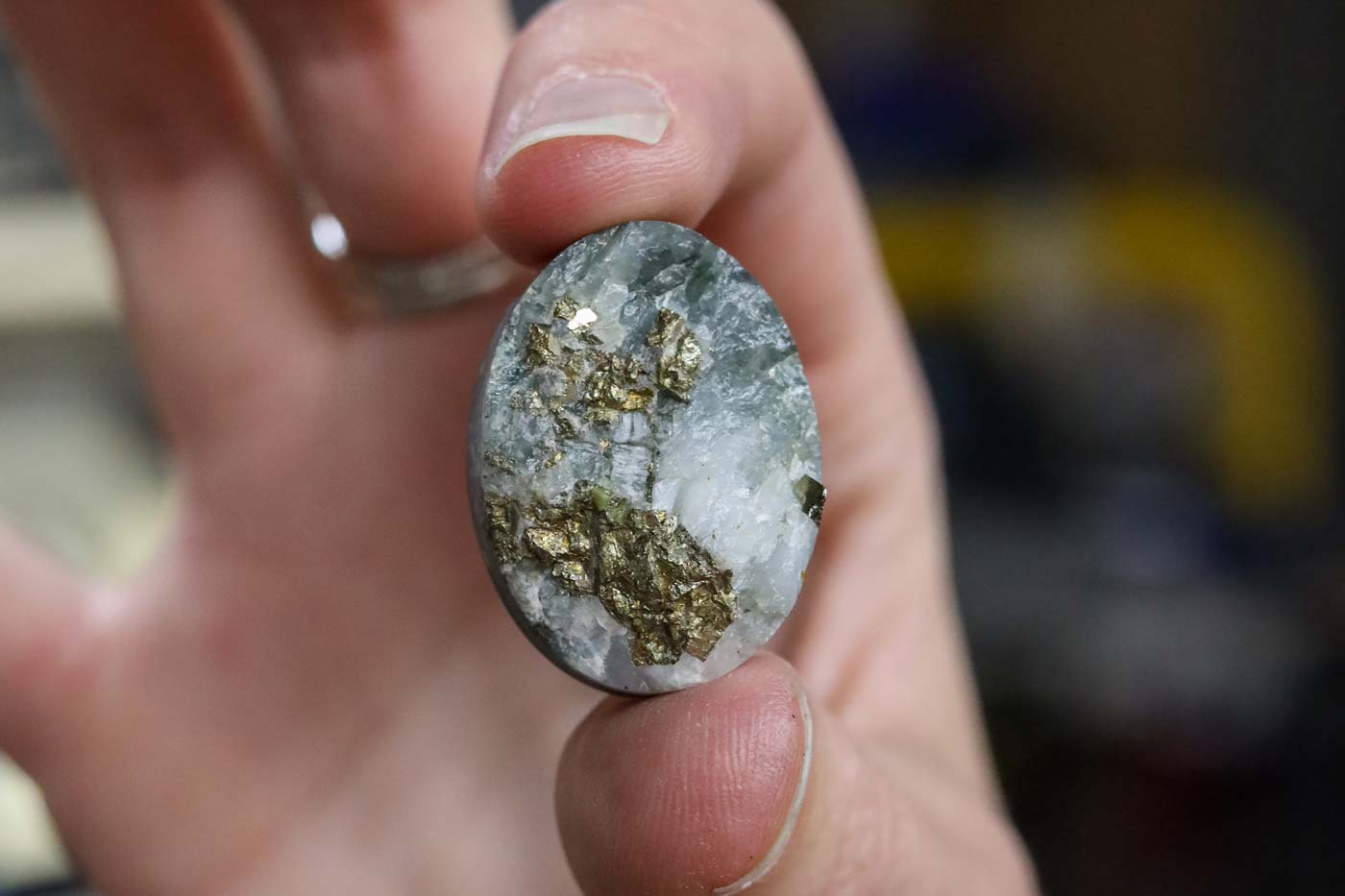 A gray stone with gold pyrite and crystal inclusions
