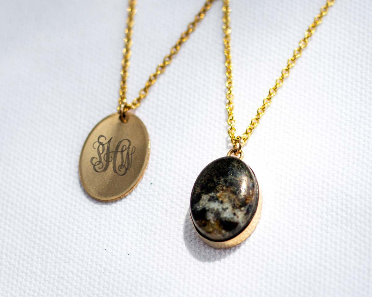 A gold charm and a stone pendant set in gold, both made with 14k gold fill