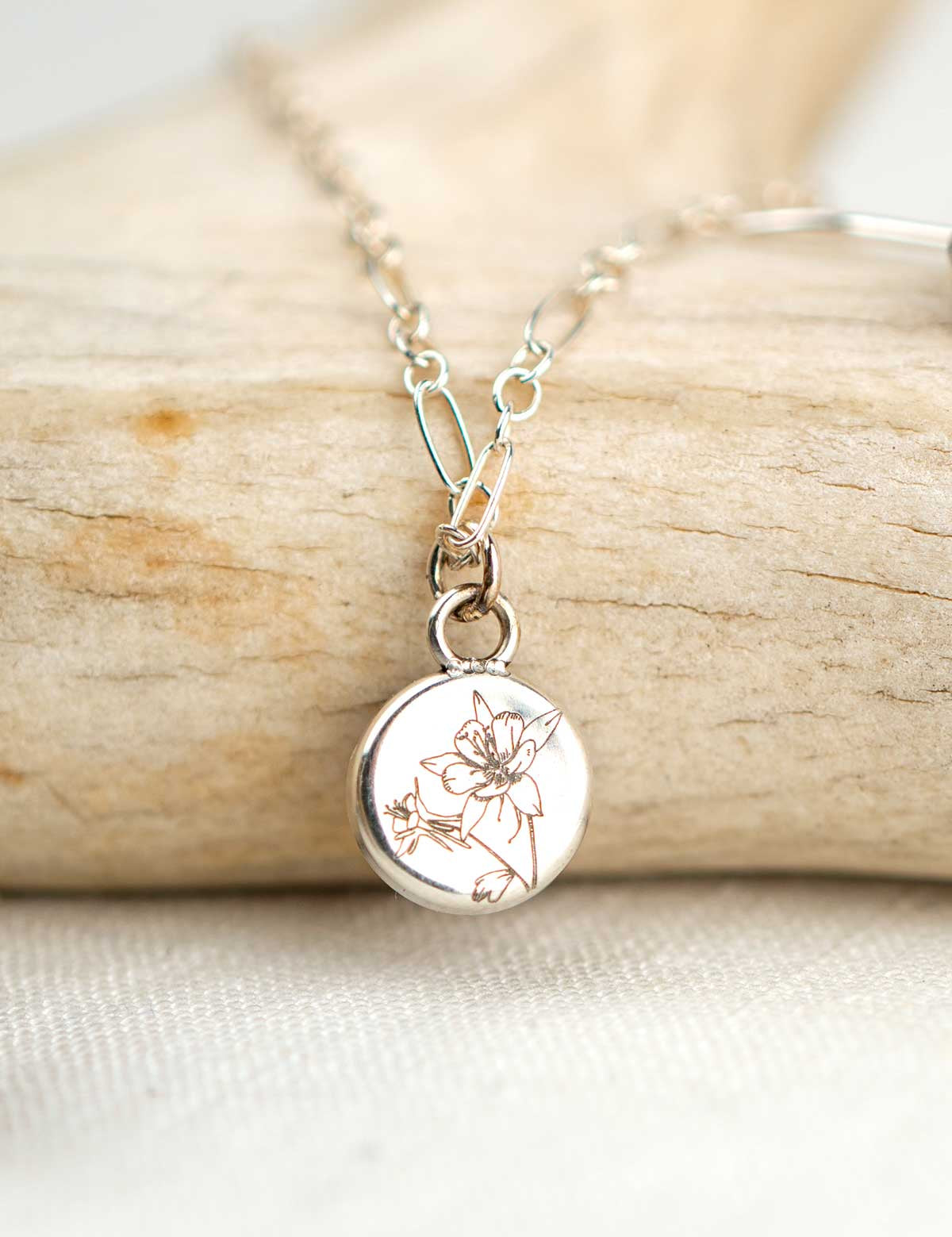 Sterling silver necklace engraved on the back with an illustration of a columbine flower
