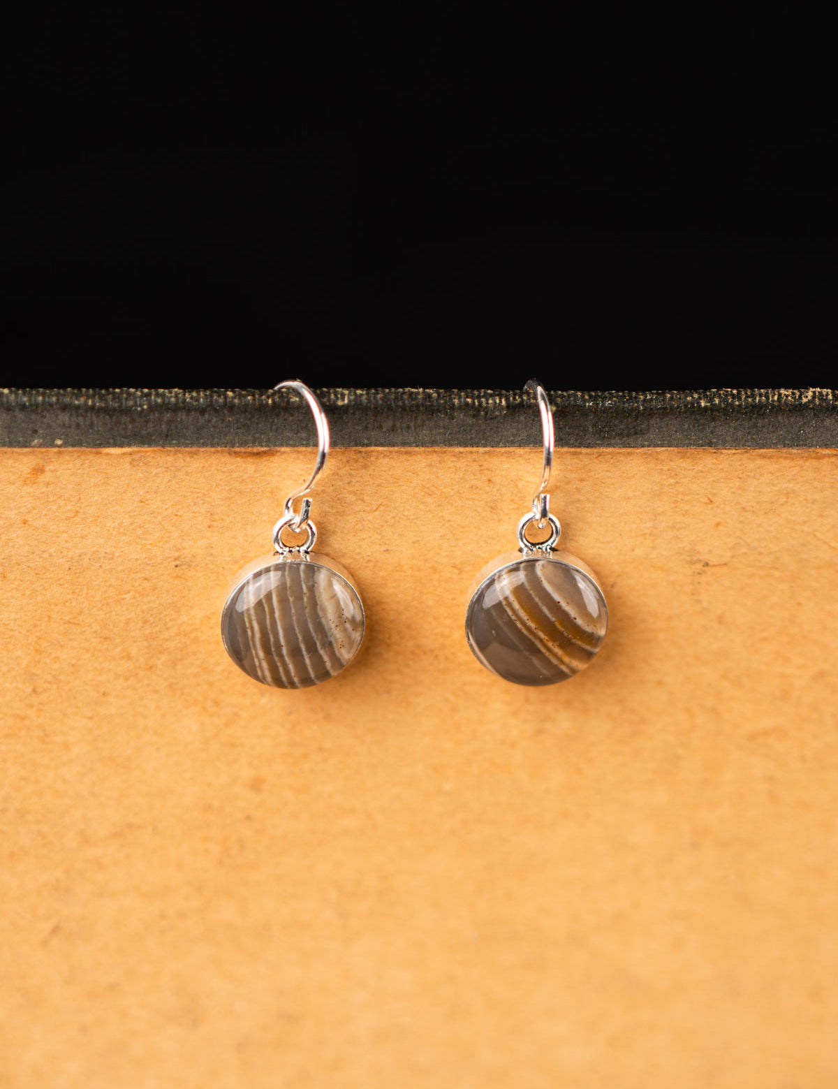 Pair of round dangling stone earrings made from gray striped chert