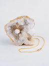Dainty 14k gold fill pendant necklace made from roughly cut white quartz that came from the geode the necklace is displayed on