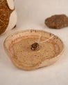 Ceramic dish with a necklace featuring a round pendant made from natural speckled granite