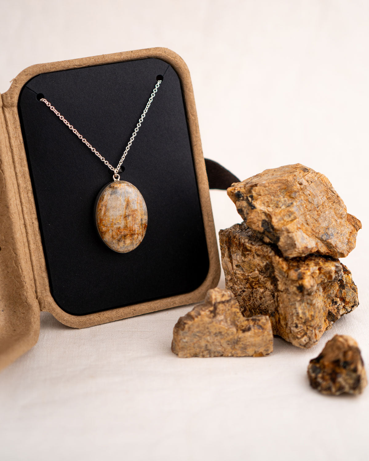Sterling silver necklace with a large stone pendant in a kraft gift box with the original stones it was made from