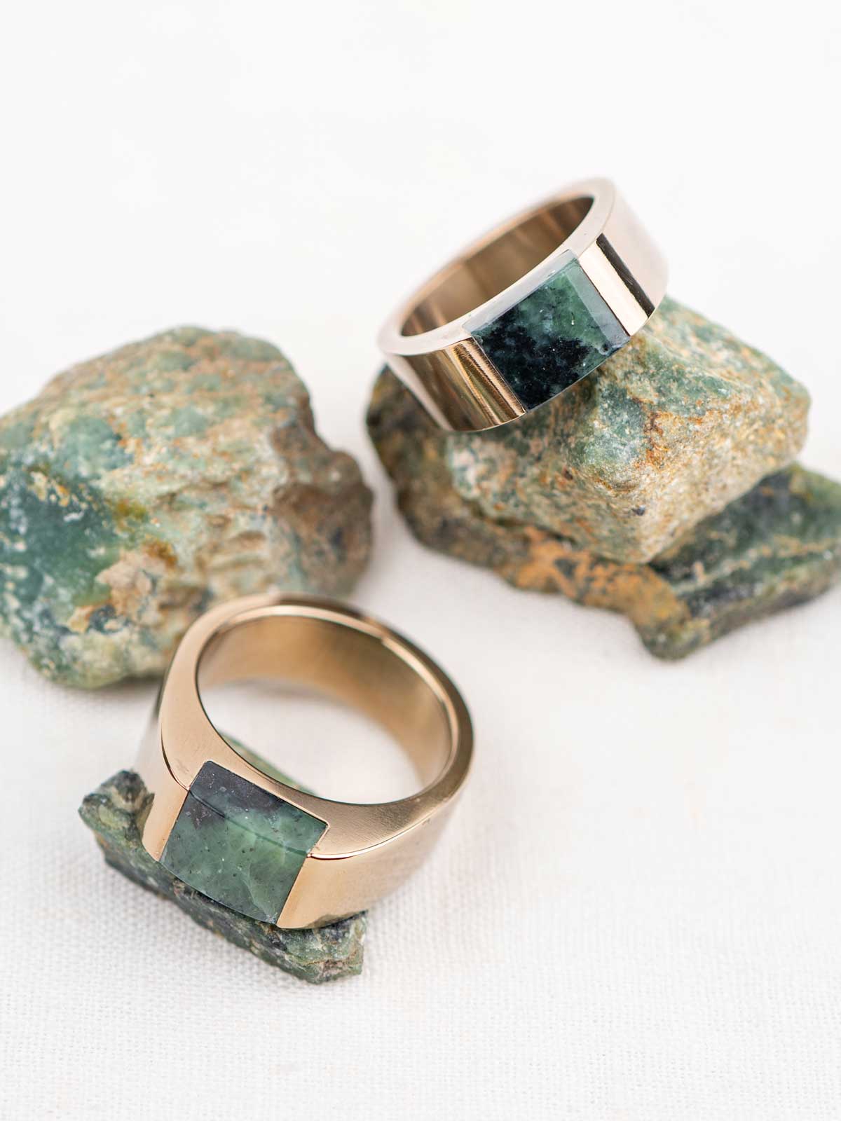Two chunky champagne color stainless steel rings with matching natural green stones