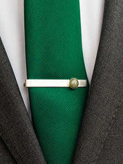 Green tie with a sterling silver tie clip set with a round green stone and custom engraved with the initial 'G'