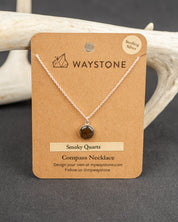 Waystone smoky quartz compass necklace on a brown card with deer antlers in the background