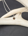 Sterling silver necklace with a pendant made of smoky quartz on a dark surface with antlers