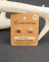 Waystone smoky quartz confluence stud earrings on a kraft paper card with antlers in the background