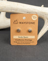 Waystone smoky quartz confluence stud earrings on a kraft paper card with antlers in the background