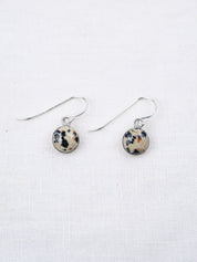 Pair of earrings with round, multicolored stones on a white background
