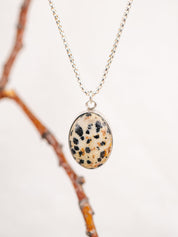Necklace with a dalmatian Jasper pendant against a white background