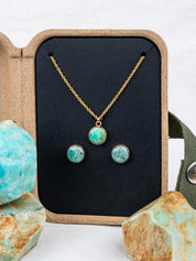 Stone jewelry set with necklace and earrings in a kraft gift box, surrounded by the rocks they were made from