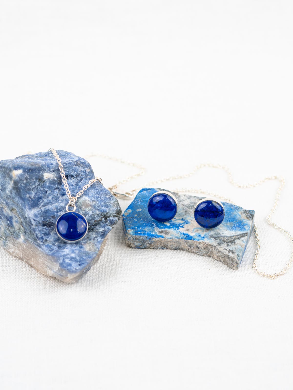 Blue stone jewelry set with round polished stones; includes a pendant necklace on a chain and stud earrings