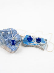 Blue stone jewelry set with round polished stones; includes a pendant necklace on a chain and stud earrings