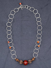 Sterling Silver Faceted Fire Agate necklace photographed on a gray background
