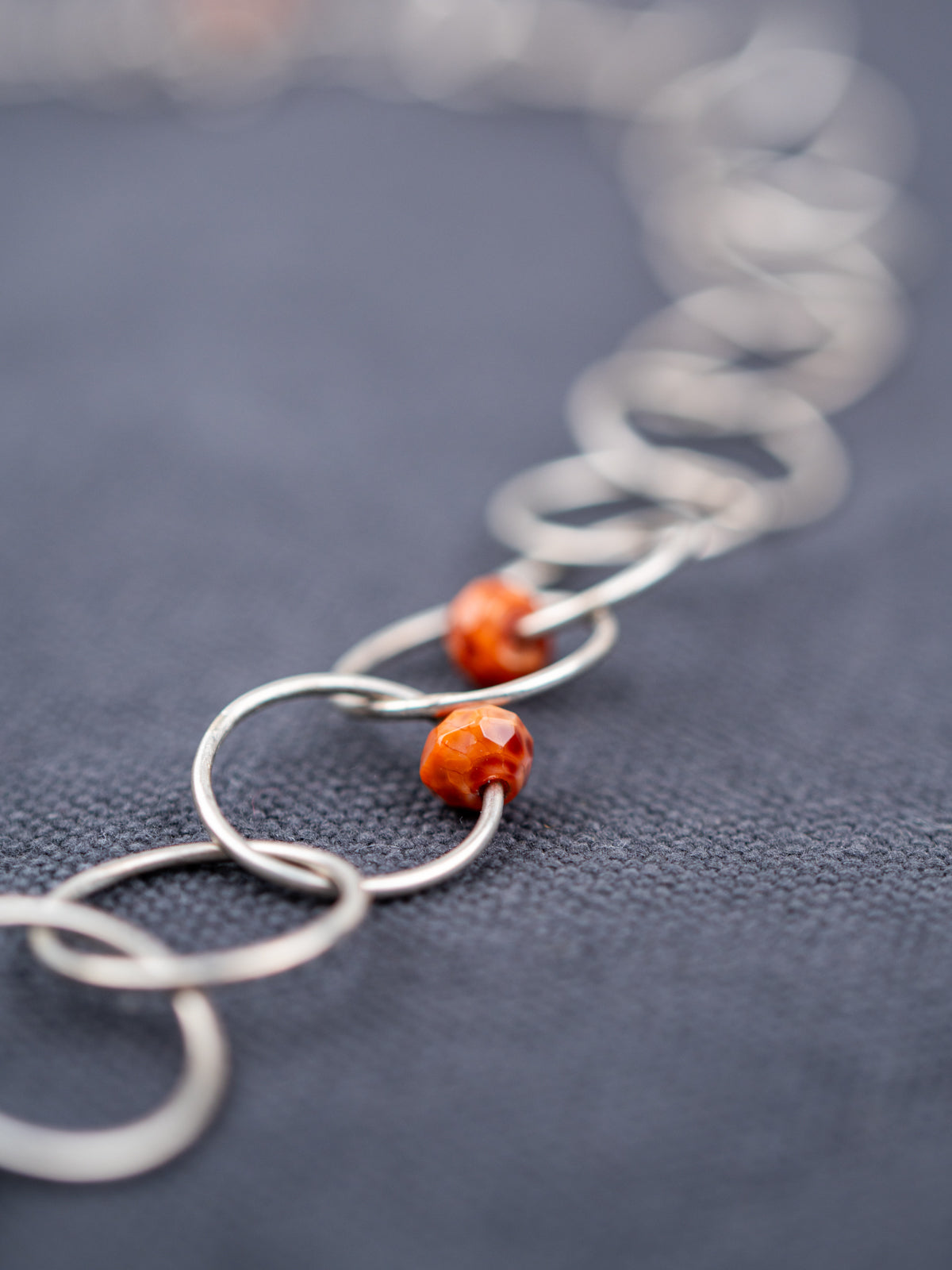 Close-up of the Faceted Fire Agate, photographed on a gray background