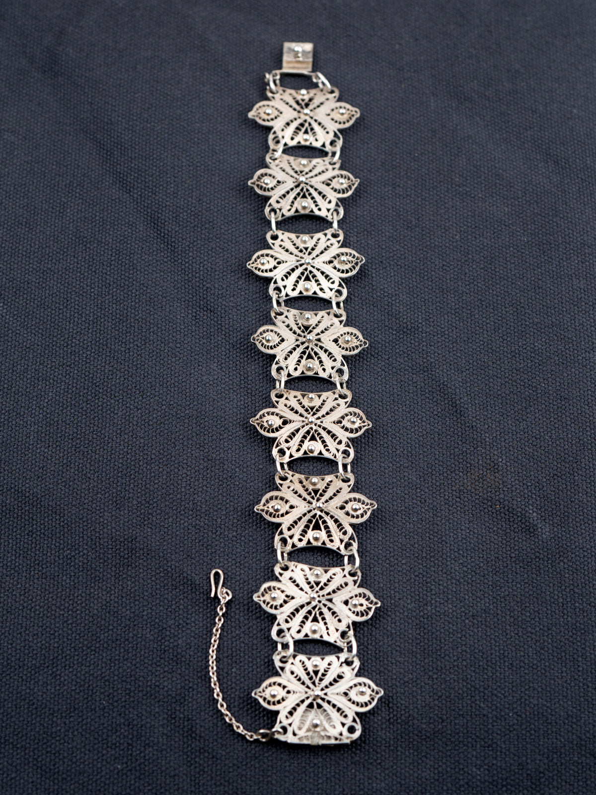 Sterling Silver chain bracelet on a gray fabric background