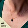 A small round stone pendant on a 14k gold chain. It's custom made—you send the stone!