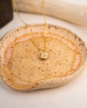 Gold necklace with a pendant engraved with a sun