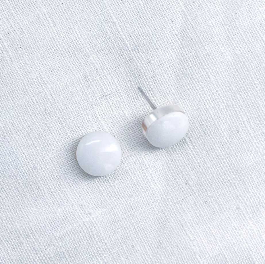 Side view of a pair of white marble stud earrings
