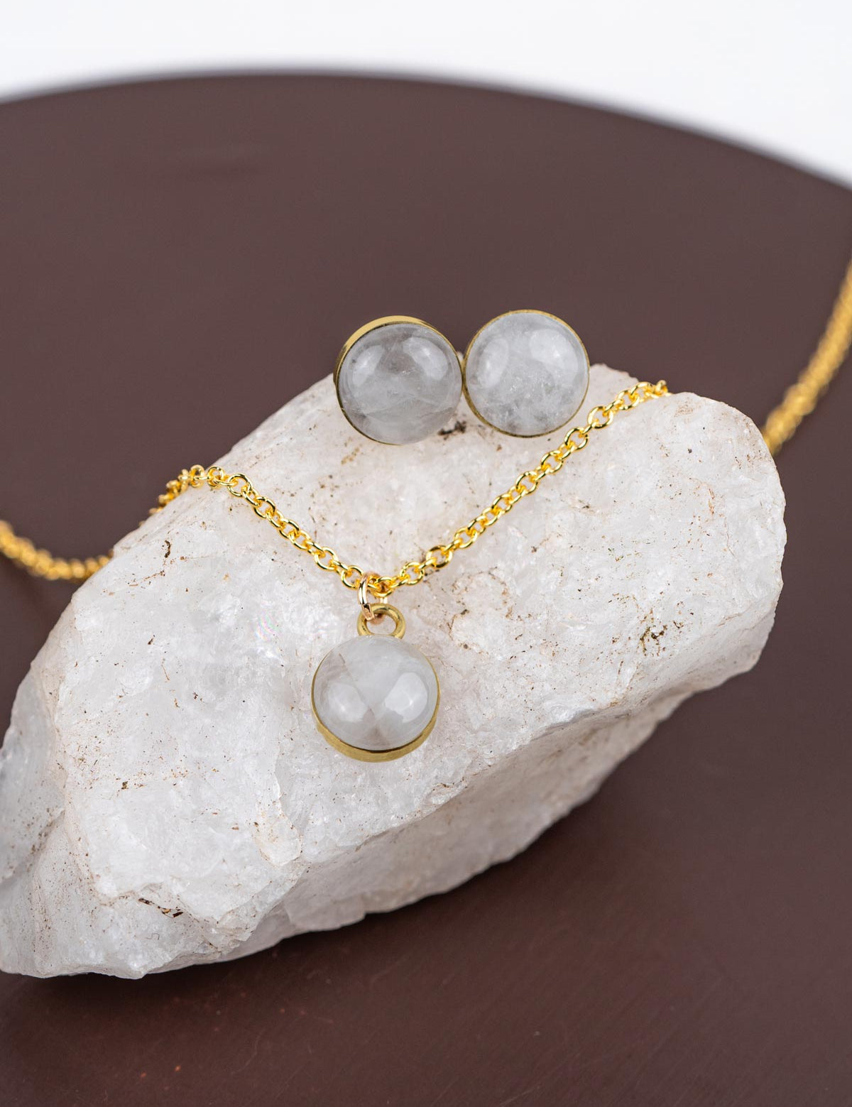 Mini jewelry set with a pendant on a gold fill chain and stud earrings, each set with round polished crystal stones