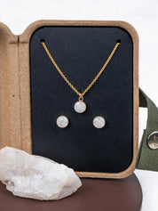 Mini jewelry set with necklace and stud earrings in a kraft gift box, next to the original natural rock they were made from