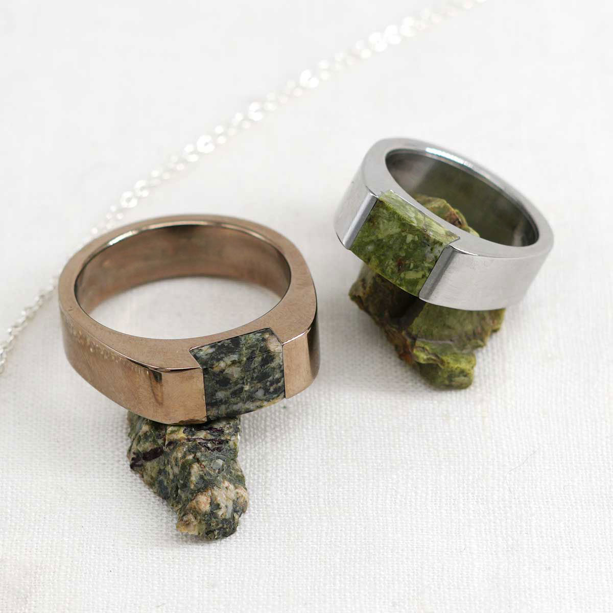 Two stainless steel rings set with natural green stones, one champagne color steel and one silver color steel