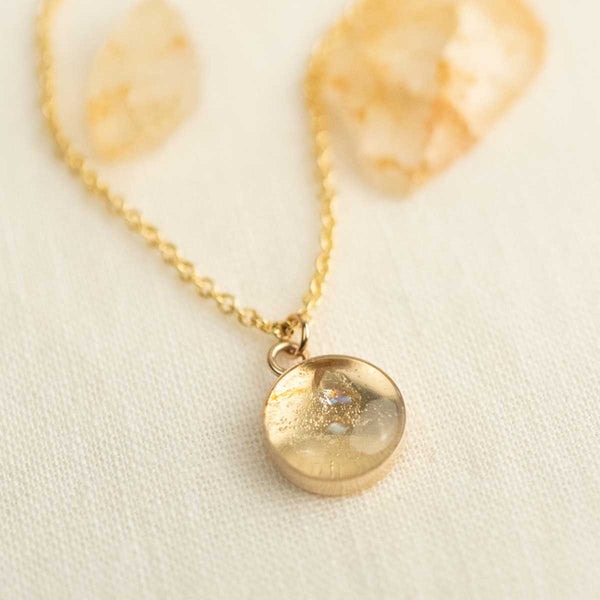 14k gold fill necklace with a round crystal pendant on a light background