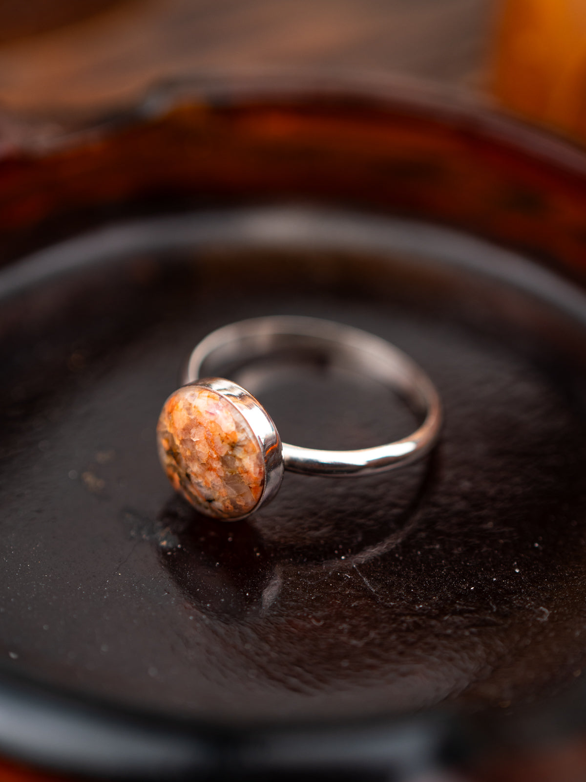 Silver ring with an pink stone on a dark surface