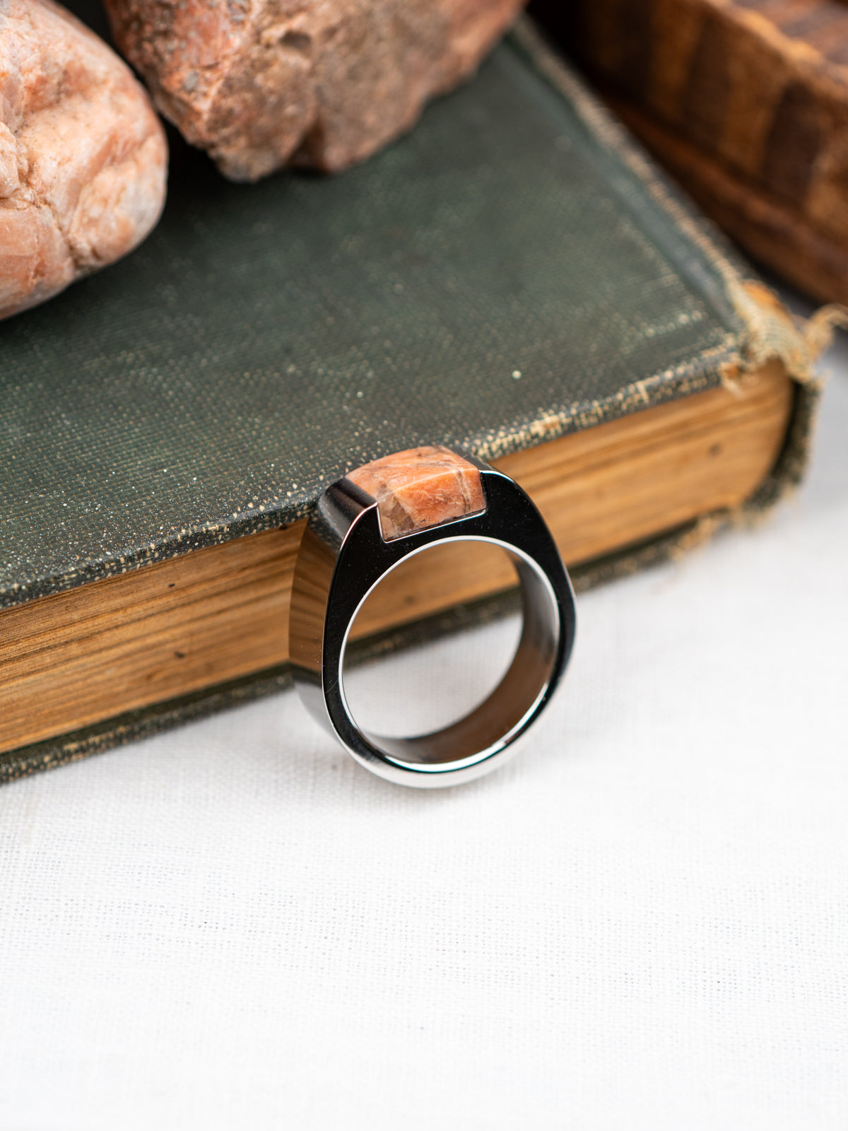 silver ring with a stone on an old book