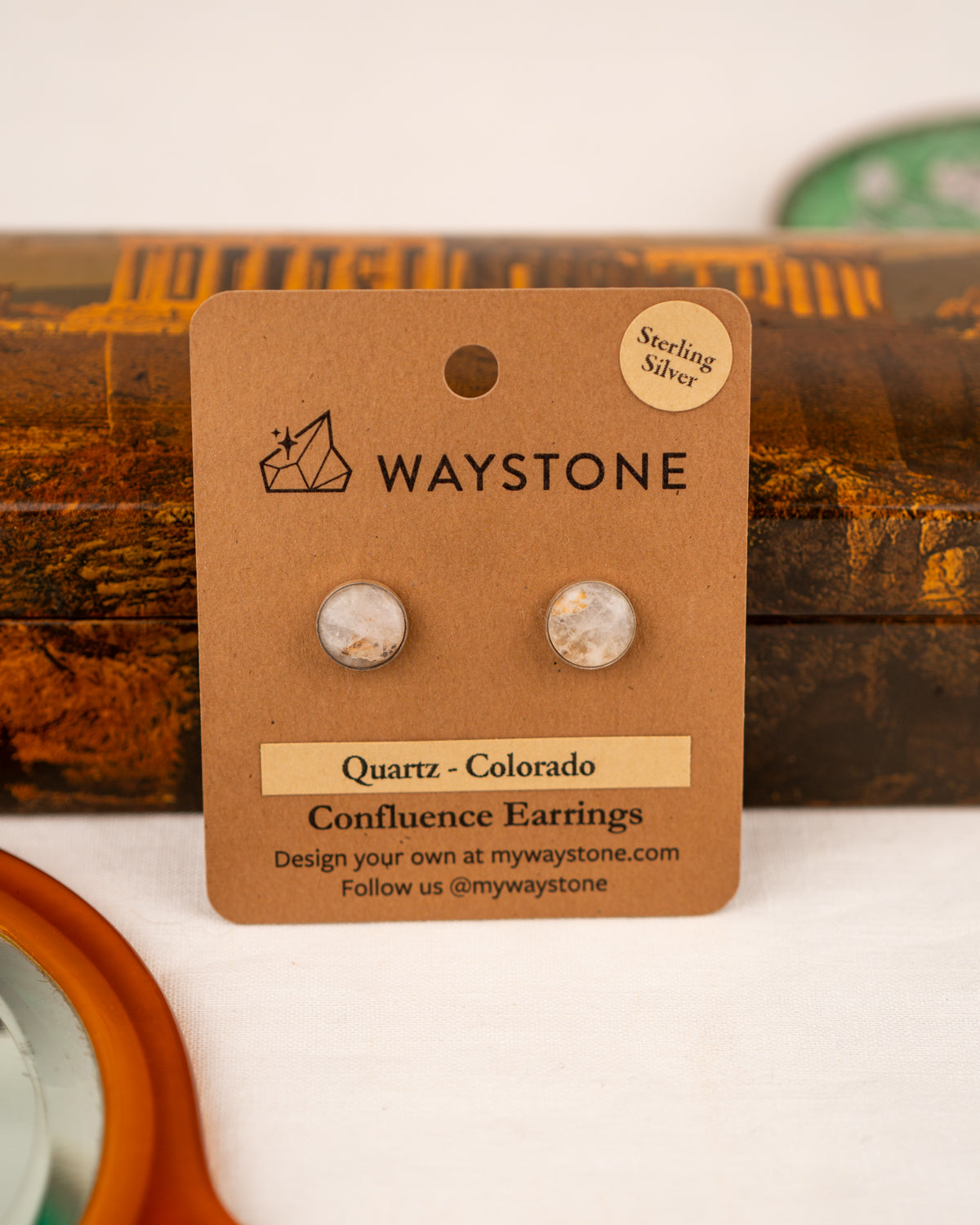 White colored milky quartz earrings on a Waystone branded card
