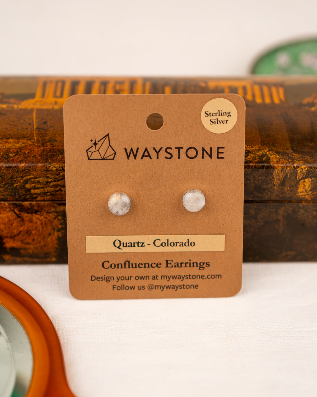 White colored milky quartz earrings on a Waystone branded card