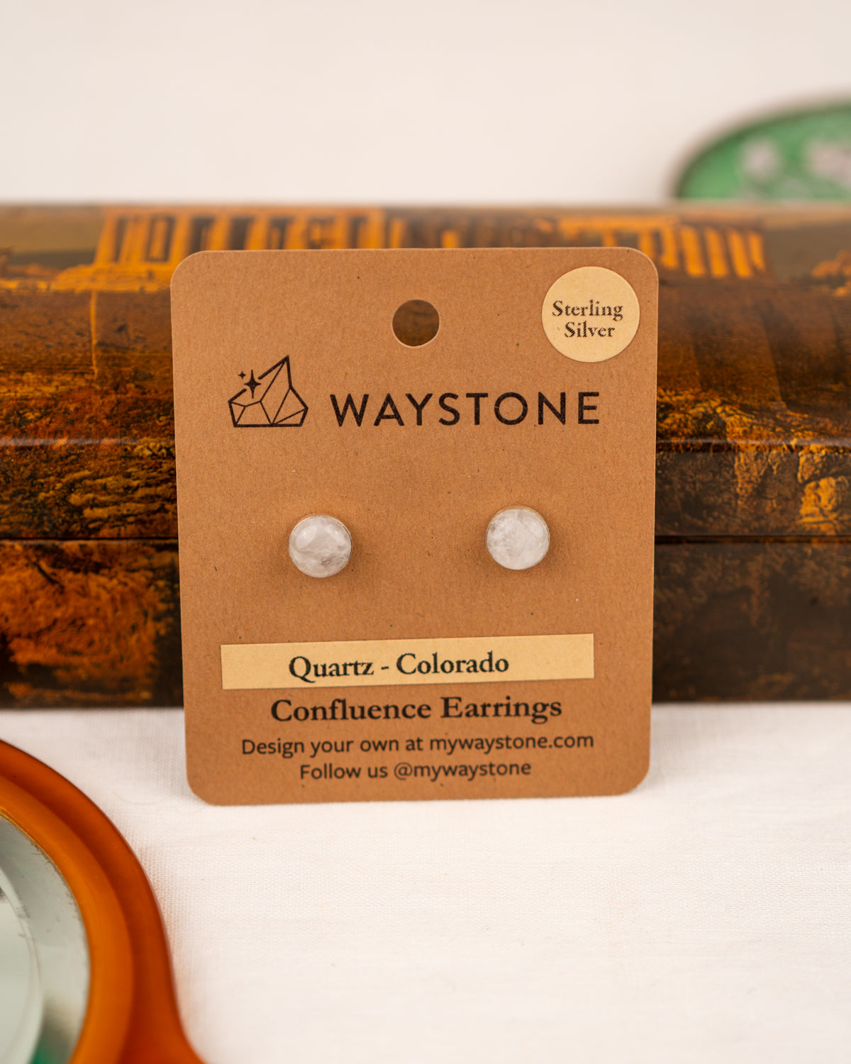 White colored milky quartz earrings on a Waystone branded card