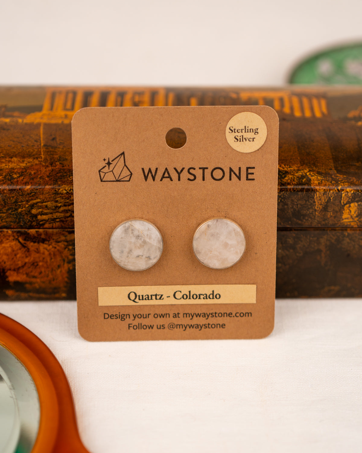 White colored milky quartz earrings on a Waystone branded card