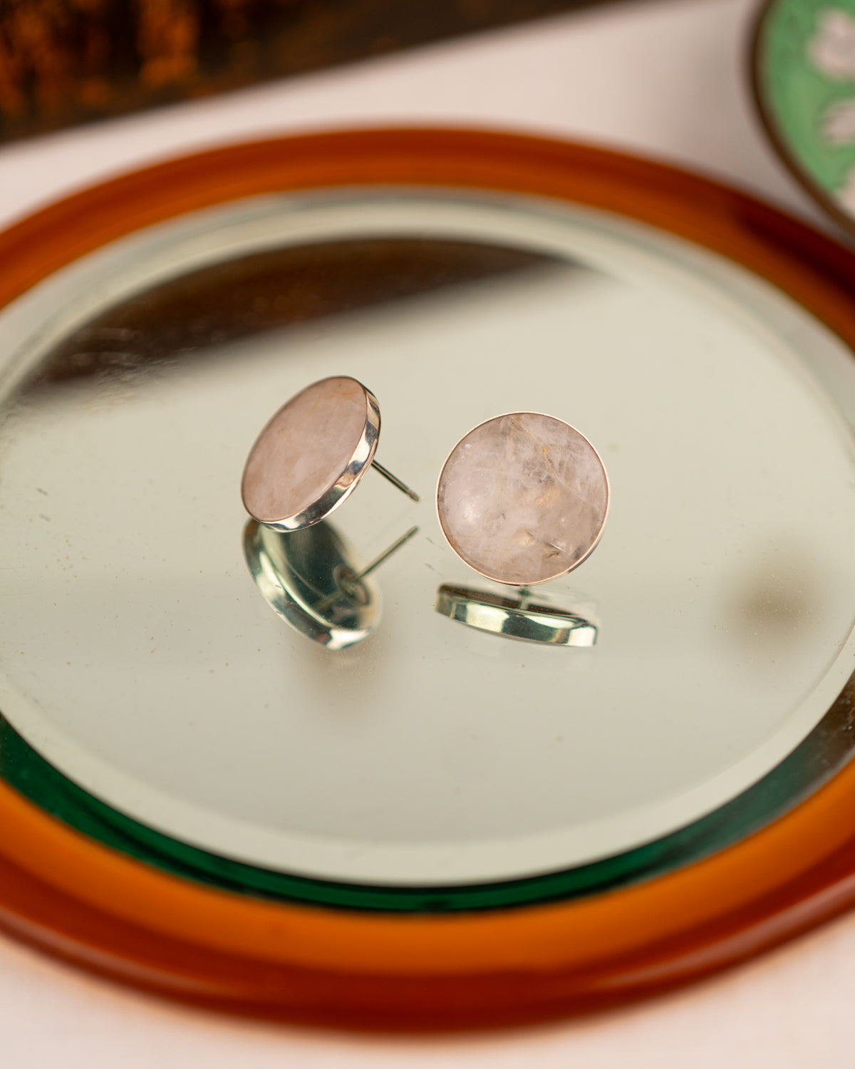 White colored milky quartz earrings on a mirror