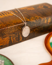 White colored milky quartz set into a sterling silver pendant draped over a box