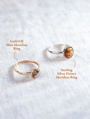 Two minimalist stone rings, one labeled Gold Fill Mini Meridian Ring and one labeled Sterling Silver Dainty Meridian Ring