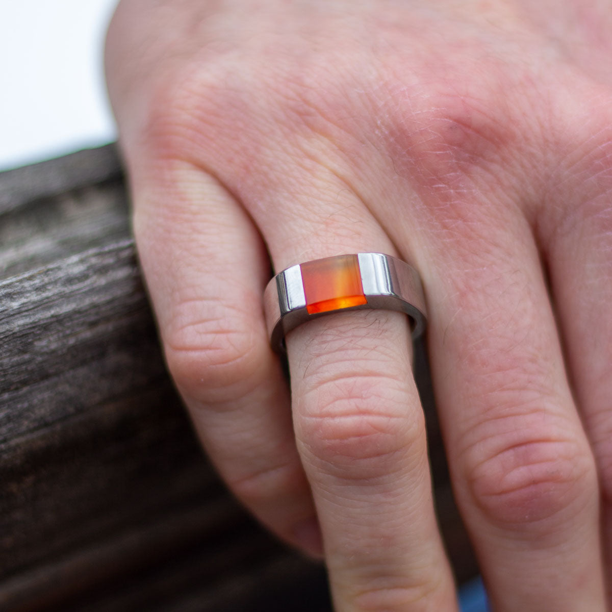 Man wearing stainless steel ring with custom orange inset stone