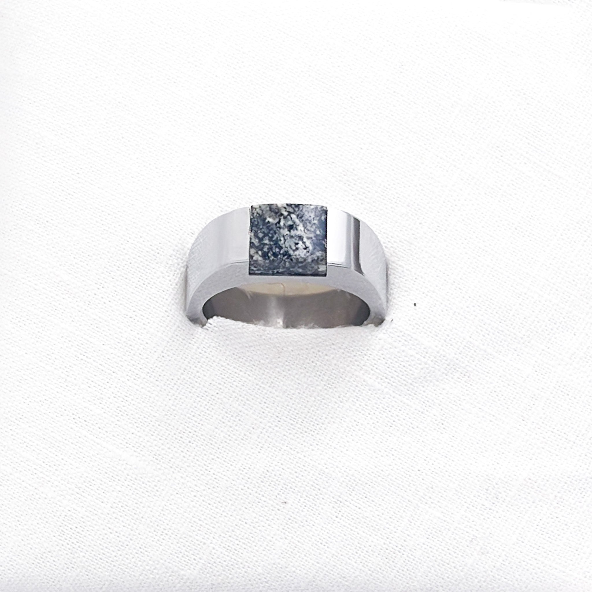 A stainless steel signet ring with an inset black granite stone