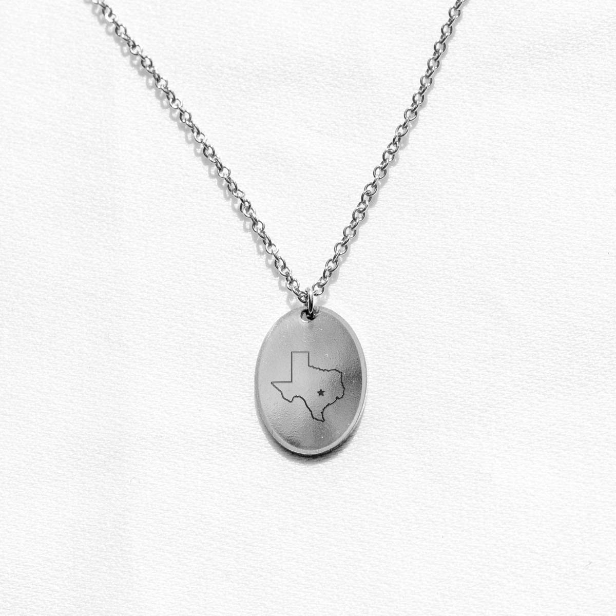 Sterling silver charm necklace with an engraving of the state of Texas