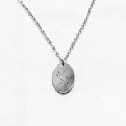 Sterling silver charm necklace with an engraving of the Gemini zodiac sign