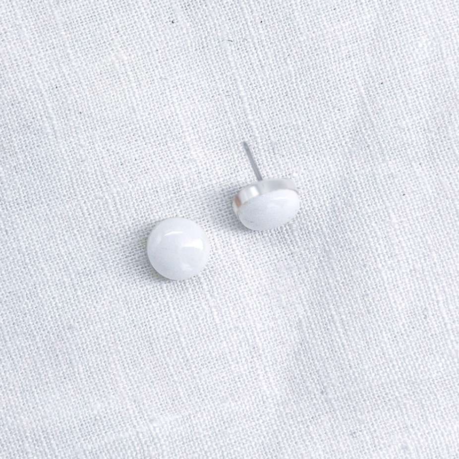 Side view with a pair of 8mm round white marble stud earrings