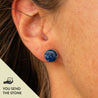 Close-up of an ear wearing a blue lapis stud earring with the text "you send the stone" in the corner
