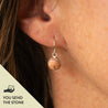 Sterling silver dangle earrings with a round stone, suspended from a silver loop, worn on an ear. Text in corner reads "you send the stone."