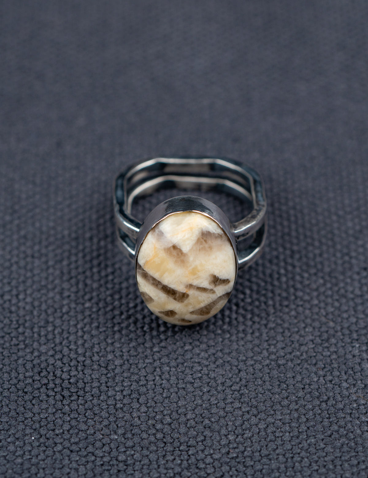 Zebra stone statement ring with a polished oval stone featuring natural brown and cream striations, set in a handcrafted metal bezel with a double-banded shank.