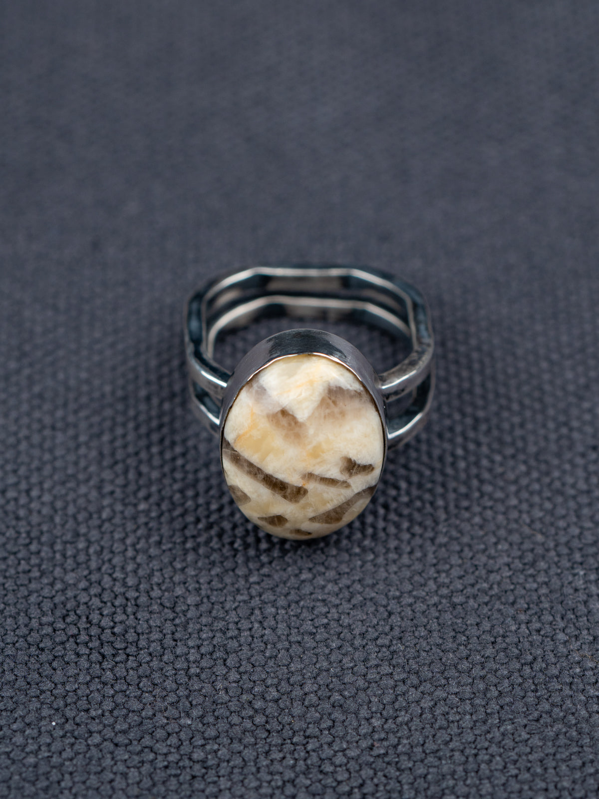 Zebra stone statement ring with a polished oval stone featuring natural brown and cream striations, set in a handcrafted metal bezel with a double-banded shank.