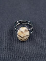 Zebra stone statement ring with a polished oval stone featuring natural brown and cream striations, set in a handcrafted metal bezel with a double-banded shank.