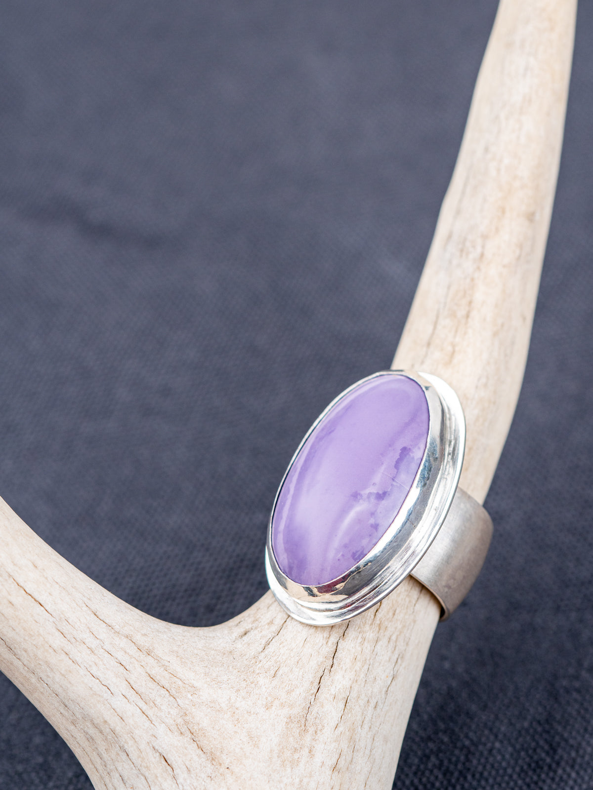 Sterling silver ring featuring a Tiffany stone with natural purple tones on a pale antler
