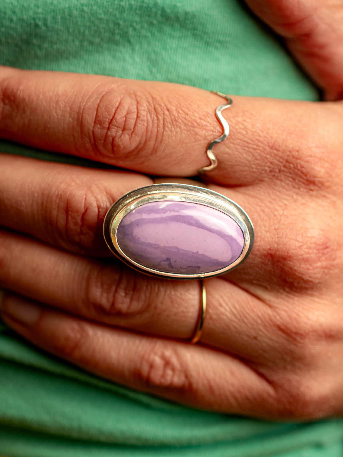 Sterling silver Tiffany stone ring photographed on the middle finger of a person